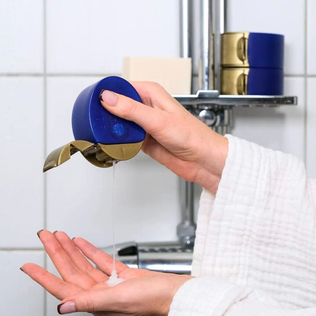 Händer som klämmer ut produkt från en Bottler reseflaska.